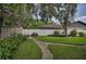 Well-maintained backyard with lush greenery, a winding pathway, and a white privacy fence at 11279 Oakridge Trl, Seminole, FL 33772