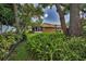 Lush backyard featuring mature trees, ferns, and a glimpse of the home's screened-in porch at 11279 Oakridge Trl, Seminole, FL 33772