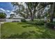 Spacious backyard with lush green grass, mature trees, and a white fence for privacy at 11279 Oakridge Trl, Seminole, FL 33772