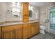 Well-lit bathroom featuring double sinks, granite countertops and two oval framed mirrors at 11279 Oakridge Trl, Seminole, FL 33772