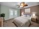 Staged bedroom featuring french doors, ceiling fan, and neutral carpet at 11279 Oakridge Trl, Seminole, FL 33772