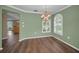 Cozy dining room featuring stylish chandelier, hardwood floors, and a large window at 11279 Oakridge Trl, Seminole, FL 33772