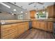 Spacious kitchen featuring wood cabinets, stainless appliances, stone countertops and an open floorplan at 11279 Oakridge Trl, Seminole, FL 33772
