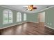 Empty Living room featuring three large windows and hardwood floors at 11279 Oakridge Trl, Seminole, FL 33772