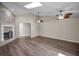 Open living room with vaulted ceilings, skylight, tile fireplace, ceiling fans, and wood floors at 11279 Oakridge Trl, Seminole, FL 33772