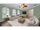 Bright living room with three large windows, modern furniture, and stylish ceiling fan at 11279 Oakridge Trl, Seminole, FL 33772