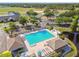 Aerial view of the community pool featuring lounge chairs, covered picnic areas, and walking trails at 11304 Plumtree Ct, Riverview, FL 33579