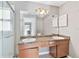 Bathroom featuring double sinks, spacious vanity, and a shower with glass doors at 11304 Plumtree Ct, Riverview, FL 33579