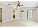 Spacious bedroom featuring tile flooring, ceiling fan, and access to the ensuite bathroom at 11304 Plumtree Ct, Riverview, FL 33579