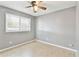 Bedroom with tile flooring, ceiling fan, and large window for natural light at 11304 Plumtree Ct, Riverview, FL 33579