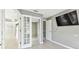 Bedroom with french doors, tile floors, and neutral gray walls at 11304 Plumtree Ct, Riverview, FL 33579