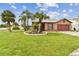 A cozy single-story home with a lush green lawn, complemented by swaying palm trees and vibrant landscaping at 11304 Plumtree Ct, Riverview, FL 33579