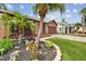 Landscaped front yard of a cozy home with tropical plants and a pathway leading to the entrance at 11304 Plumtree Ct, Riverview, FL 33579