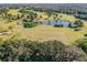 Aerial view of a golf course with trees, a pond, and walking paths at 11304 Plumtree Ct, Riverview, FL 33579