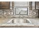 Kitchen featuring granite countertops, stainless steel sink, and tile backsplash at 11304 Plumtree Ct, Riverview, FL 33579