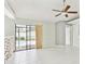 This living room features tile flooring, backyard access, and a ceiling fan at 11304 Plumtree Ct, Riverview, FL 33579