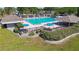 Large community pool surrounded by umbrellas, lounge chairs, picnic tables, and shaded seating areas at 11304 Plumtree Ct, Riverview, FL 33579