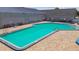 Aerial view of a large rectangular community pool with brick patio, seating, and blue umbrellas at 11304 Plumtree Ct, Riverview, FL 33579