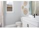 Bright bathroom featuring decorative wall hangings, a modern sink, vanity, and a large window at 12574 Somatic Ct, Venice, FL 34293
