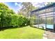 The landscaped backyard features a screened pool, green grass and lush shrubs for enhanced privacy at 15126 Shearcrest Dr, Lithia, FL 33547