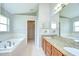Primary bathroom featuring double sinks, granite counters, soaking tub, and walk-in closet at 15126 Shearcrest Dr, Lithia, FL 33547