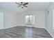 Bright bedroom features a ceiling fan, vaulted ceiling, wood-look flooring, and a window with sheer curtains at 15126 Shearcrest Dr, Lithia, FL 33547