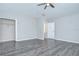 Bedroom with gray wood-look flooring features a closet and entry door with white trim at 15126 Shearcrest Dr, Lithia, FL 33547