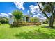 Landscaped front yard showcases lush green grass and colorful plantings around a single-story home at 15126 Shearcrest Dr, Lithia, FL 33547