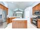 Bright kitchen featuring an island, stainless steel appliances, tile floors, and wooden cabinetry at 15126 Shearcrest Dr, Lithia, FL 33547