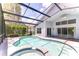 A screened pool with a spa, ceiling fan, and outdoor lighting at 15126 Shearcrest Dr, Lithia, FL 33547