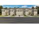 Charming townhome exterior featuring stone accents, a private garage, and manicured landscaping at 2466 Riversong Lodge Ln, Wesley Chapel, FL 33543