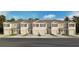 Exterior view of townhomes with garages, shutters, and landscaping under a blue sky at 2486 Riversong Lodge Ln, Wesley Chapel, FL 33543