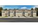 Exterior view of townhomes with garages, shutters, and landscaping under a blue sky at 2486 Riversong Lodge Ln, Wesley Chapel, FL 33543
