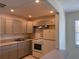 Kitchen featuring neutral cabinets and white appliances and view to living room at 2501 Harn Blvd # H20, Clearwater, FL 33764