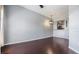 Living room with hardwood floors, a modern light fixture, and a partial view of an adjacent kitchen at 501 S Moody Ave # 1134, Tampa, FL 33609