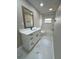 Bright bathroom with marble flooring, white vanity, and tub with black shower hardware and window at 5092 Abagail Dr, Spring Hill, FL 34608