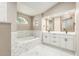 Bright primary bathroom features soaking tub, elegant marble tiling, and dual vanities at 5092 Abagail Dr, Spring Hill, FL 34608