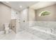 Elegant bathroom featuring a stand up shower, tub, and a large window at 5092 Abagail Dr, Spring Hill, FL 34608