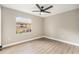 Neutral bedroom featuring light wood floors, modern ceiling fan and a bright window offering a view to the outdoors at 5092 Abagail Dr, Spring Hill, FL 34608
