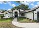 Attractive home featuring a well-manicured lawn and a two-car garage, set against a backdrop of trees at 5092 Abagail Dr, Spring Hill, FL 34608
