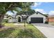 Charming single-Gathering home featuring a well-manicured lawn, mature trees, and a two-car garage at 5092 Abagail Dr, Spring Hill, FL 34608