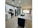Modern kitchen with white cabinets, stainless steel appliances and a kitchen island with dark blue cabinets at 5092 Abagail Dr, Spring Hill, FL 34608
