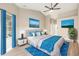 Comfortable main bedroom features a ceiling fan, bright blue accents, and a large window at 5092 Abagail Dr, Spring Hill, FL 34608