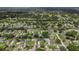 Aerial view of a lush neighborhood with well-maintained homes, mature trees, and a nearby golf course at 5092 Abagail Dr, Spring Hill, FL 34608