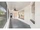 Screened patio with ceiling fan, bright white beams, and a view into the house through the window at 5092 Abagail Dr, Spring Hill, FL 34608