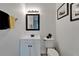 Cozy bathroom features a black framed mirror above a white vanity and toilet at 6412 Mayra Shores Ln, Apollo Beach, FL 33572