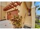 Inviting townhouse entrance, featuring a decorative pergola and beautifully landscaped yard at 6412 Mayra Shores Ln, Apollo Beach, FL 33572