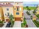 Eye-level view of a yellow townhouse, showcasing its well-kept landscaping and a two-car garage at 6412 Mayra Shores Ln, Apollo Beach, FL 33572