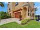 Exterior of a yellow townhouse with a two-car garage and meticulously maintained landscaping at 6412 Mayra Shores Ln, Apollo Beach, FL 33572