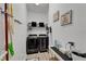Well-organized laundry room featuring modern washer and dryer with storage and charming decor at 6412 Mayra Shores Ln, Apollo Beach, FL 33572